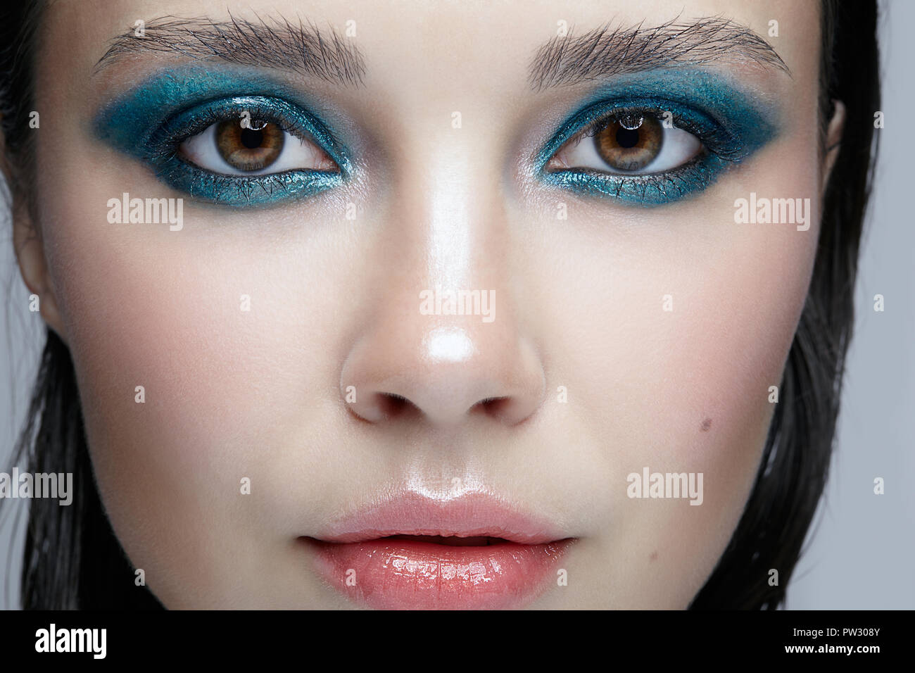 Closeup macro portrait of female face. Woman with evening beauty makeup. Girl with perfect skin and blue-green smoky eyes eye shadows Stock Photo