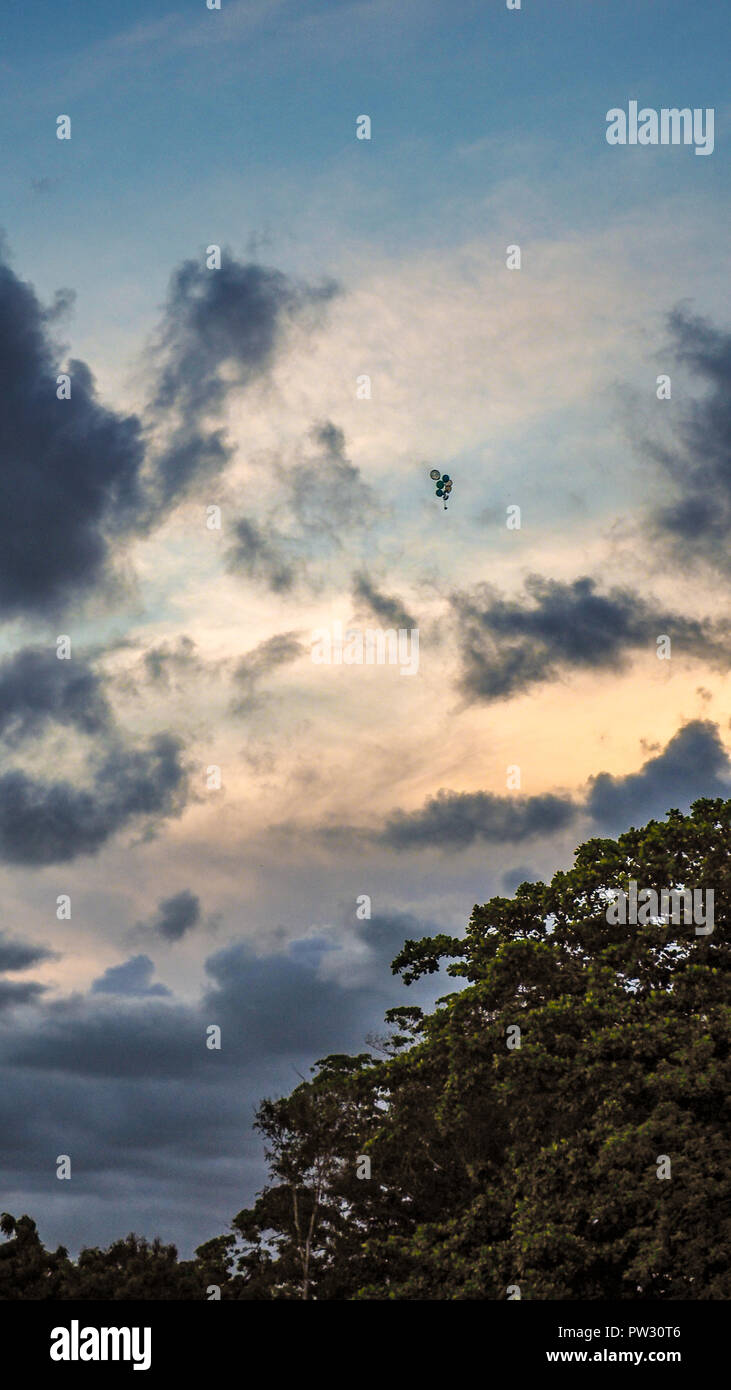 Globe with helium floating towards the sky in black and white Stock Photo