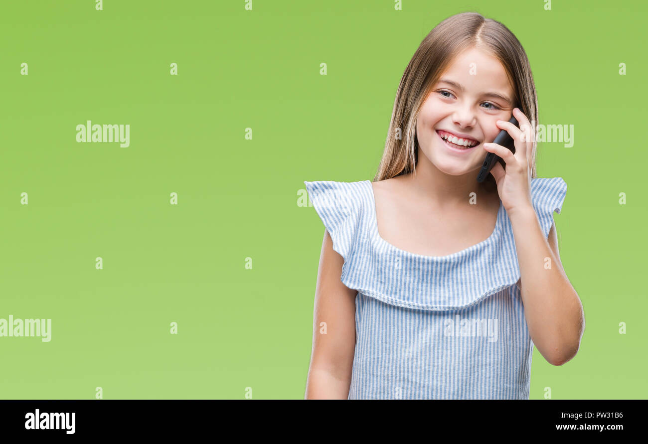 Young beautiful girl talking on the phone over isolated background with ...