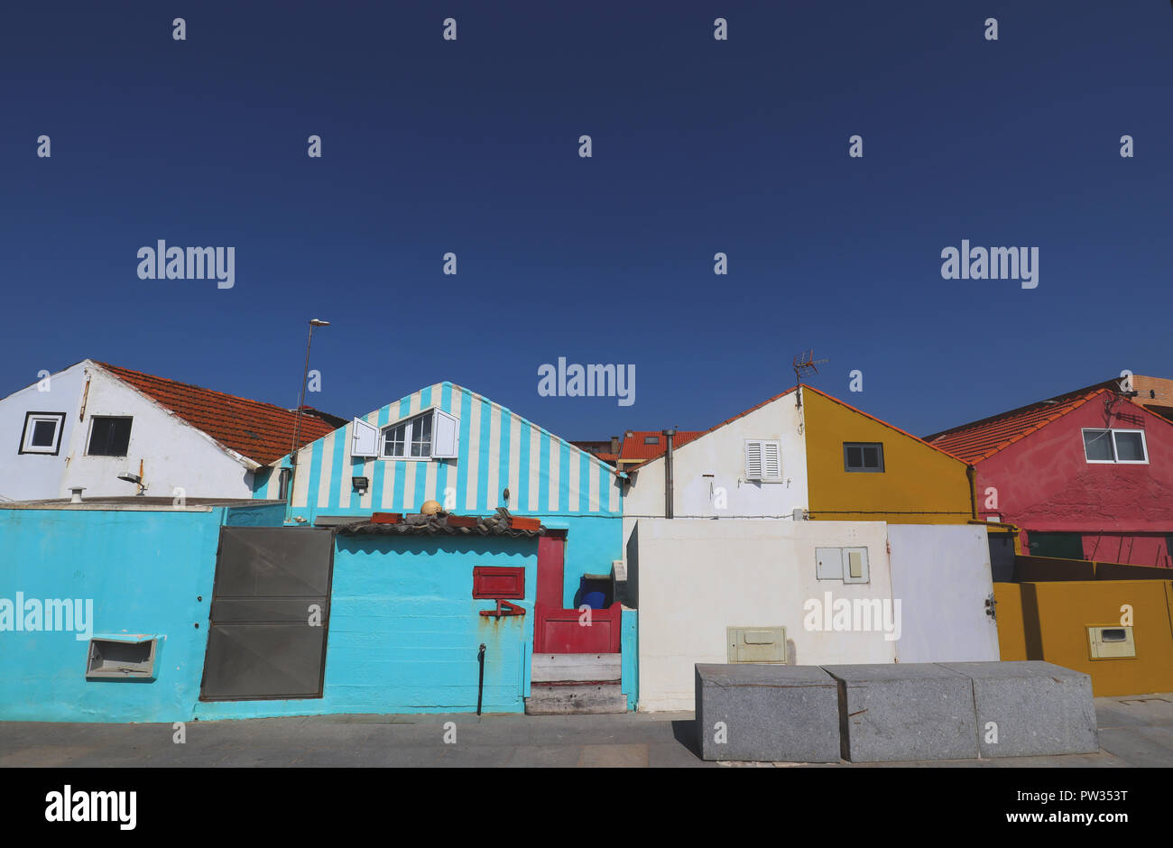 A collection of small colourful houses inhabited by fishermen along the sea front in Angeiras Portugal. Stock Photo