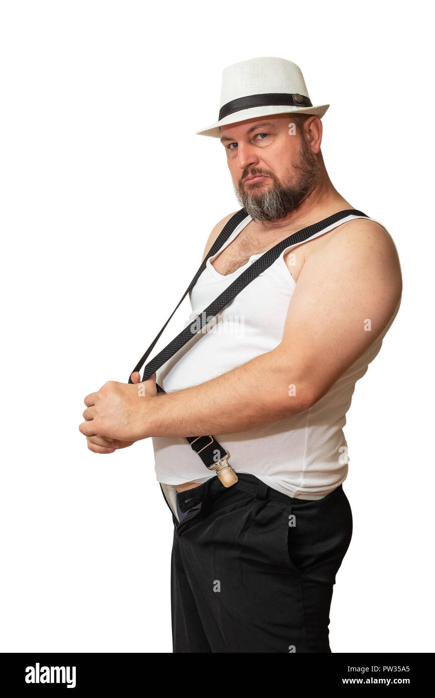 Charismatic man in a hat and t-shirt delays suspenders showing his brutality. Stock Photo