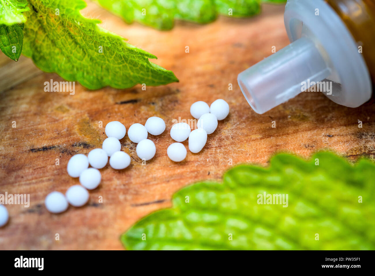 Tablets on old wooden table with green leaves Stock Photo
