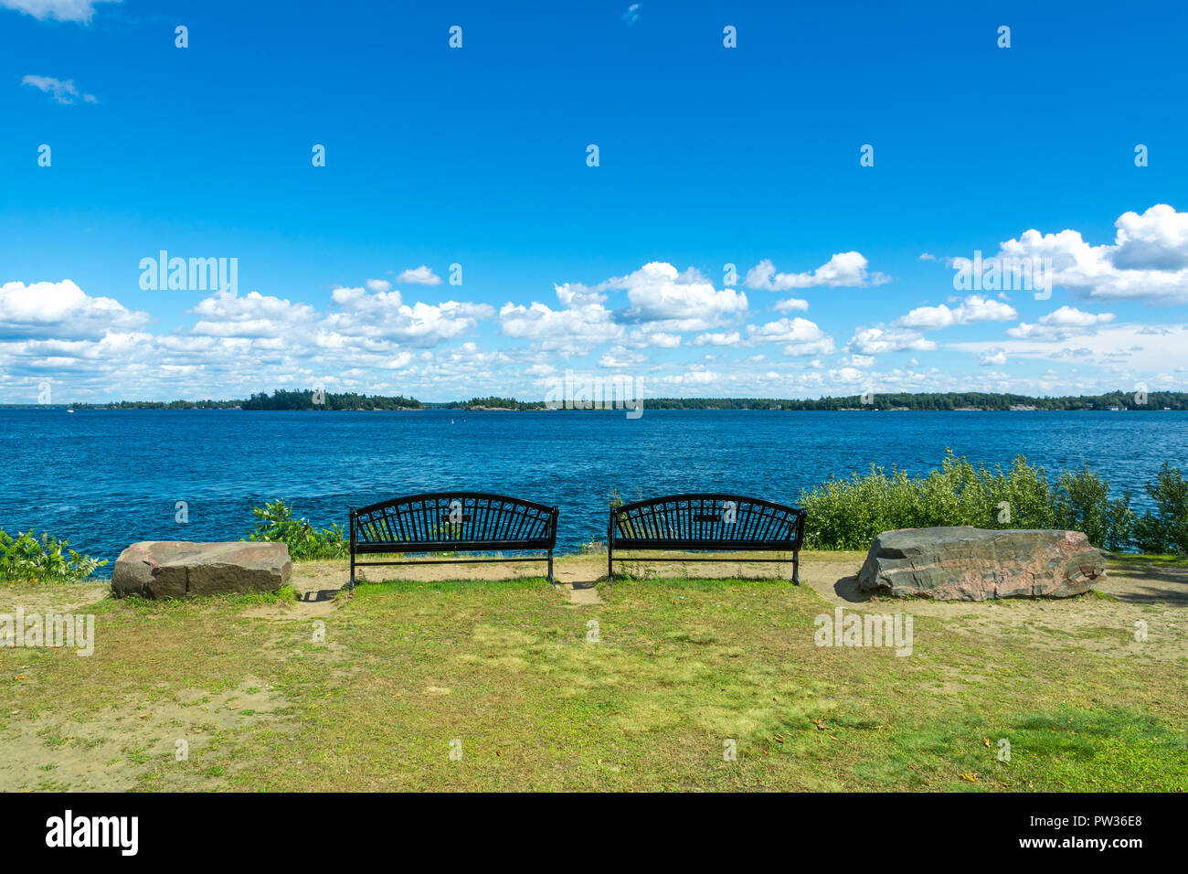 Thousan islands,Canada-august 4,2015:two benches on the banks of the one thousand islands parks in Ontario during a summer day Stock Photo