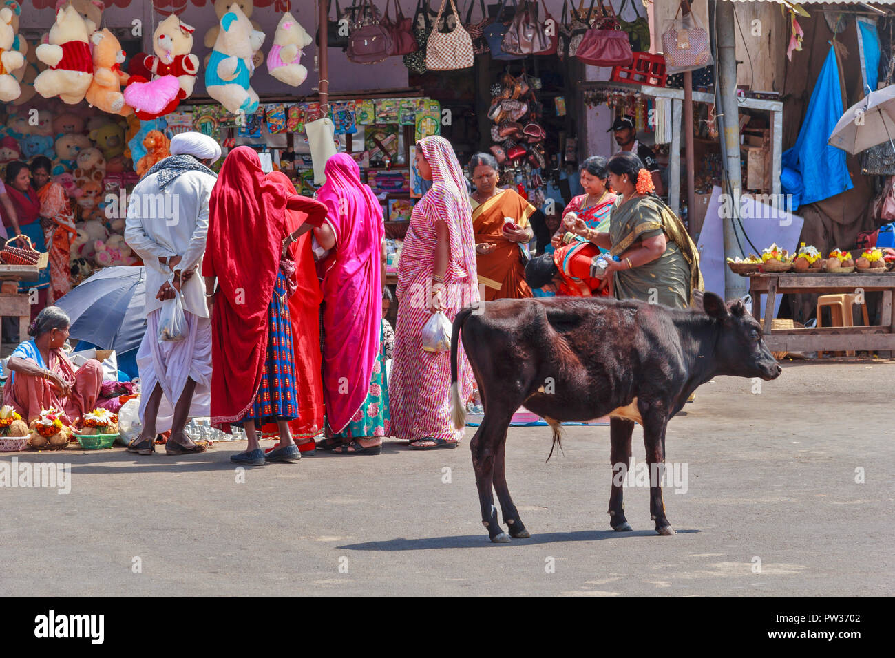 CHAMUNDI HILL MYSORE INDIA SACRED SITE PILGRIMS AND SHOPS SELLING TEMPLE OFFERINGS WITH A CALF IN THE STREET Stock Photo