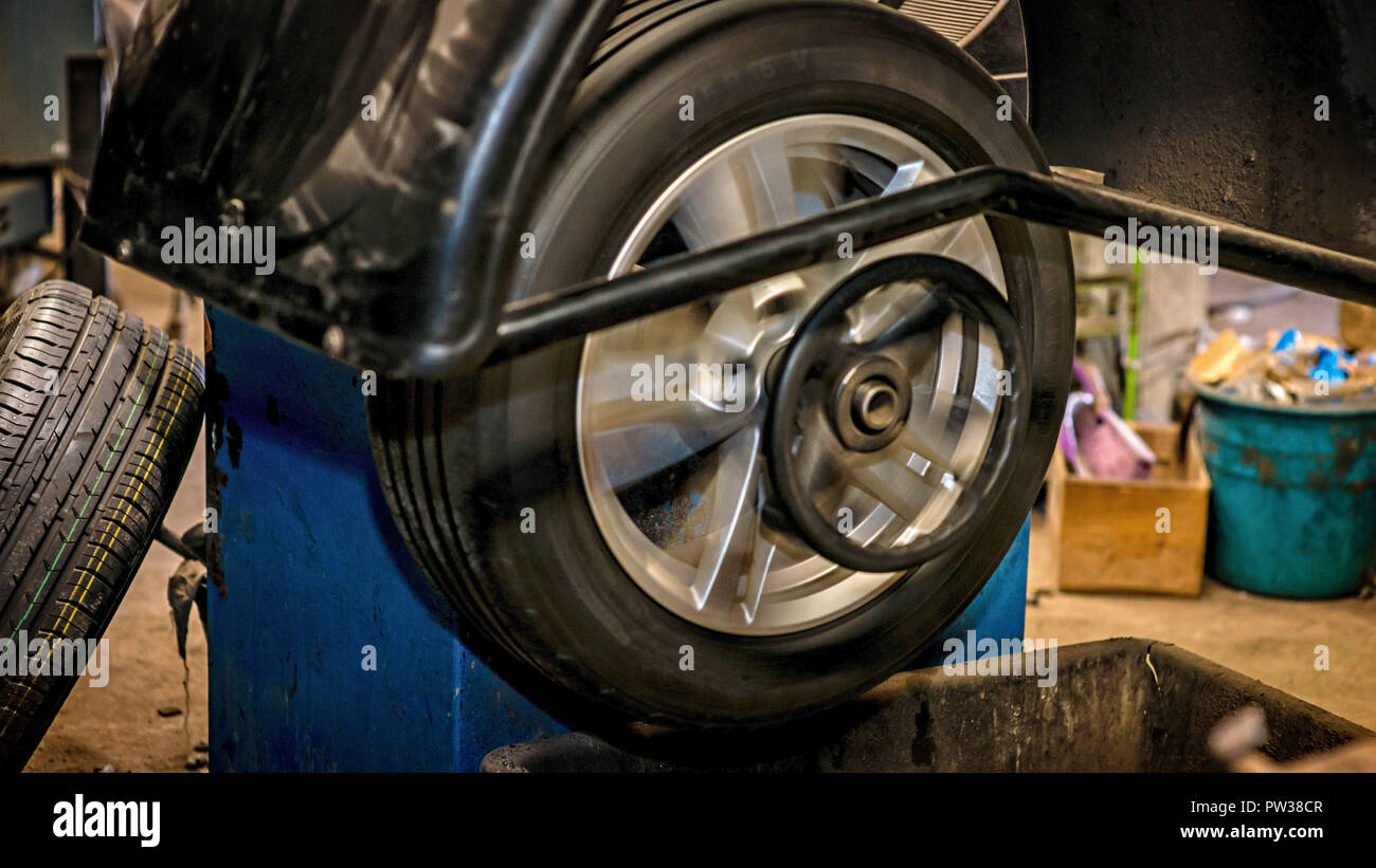 Seasonal tyre replacement. Wheel is balanced on balancing machine. Stock Photo