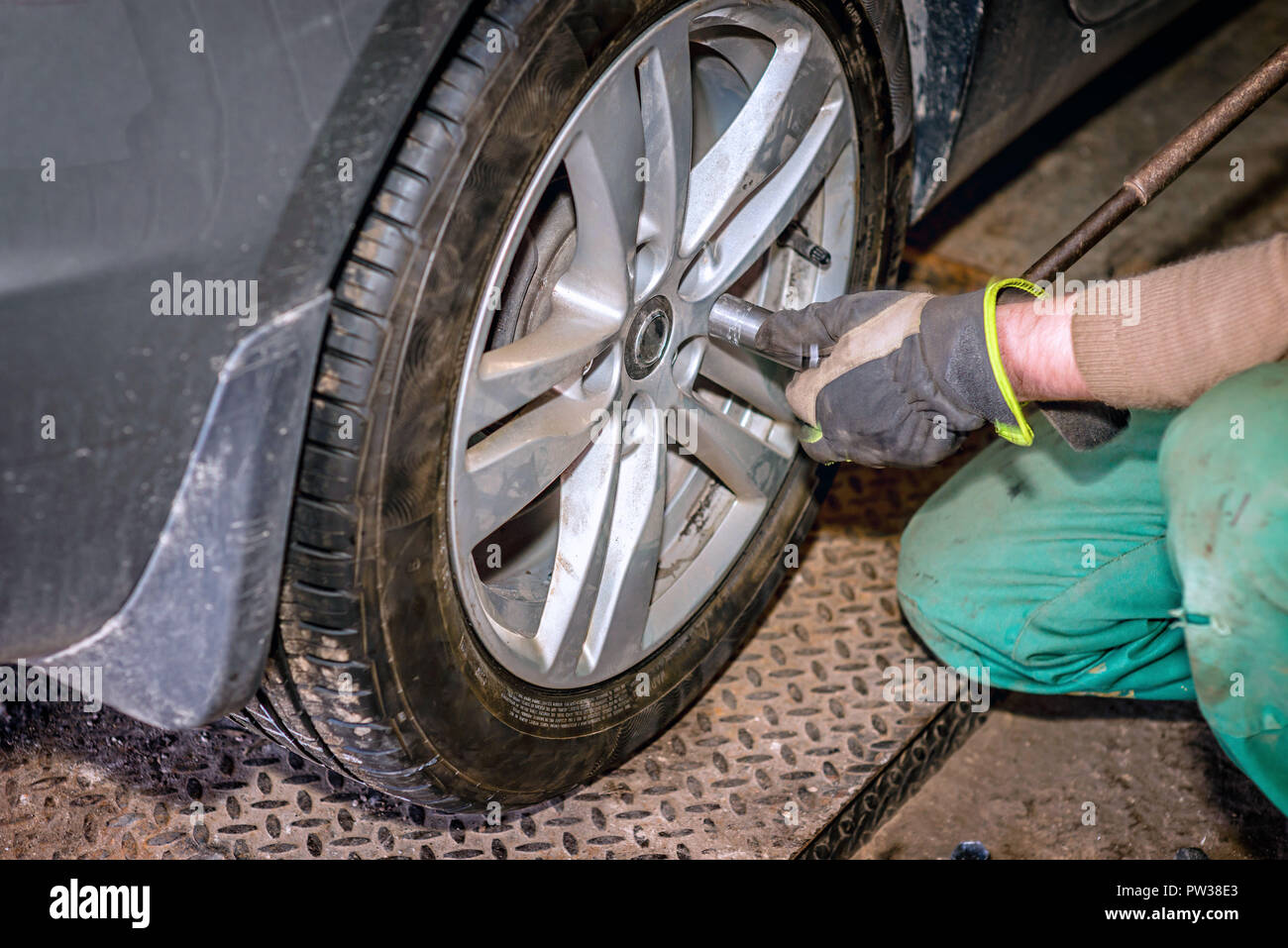 Seasonal tyre replacement. Auto mechanic changing car wheel. Stock Photo