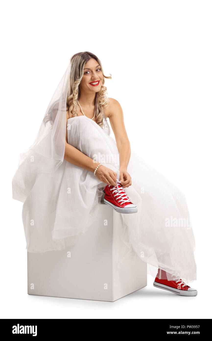 Young bride tying her shoelaces isolated on white background Stock Photo