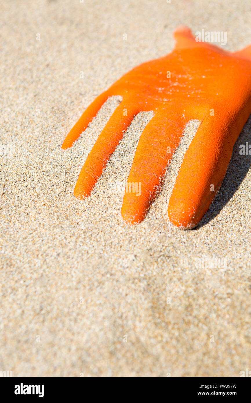 Orange rubber glove washed up on Scottish coast, Isle of Lewis, Outer Hebrides, Scotland, UK Stock Photo