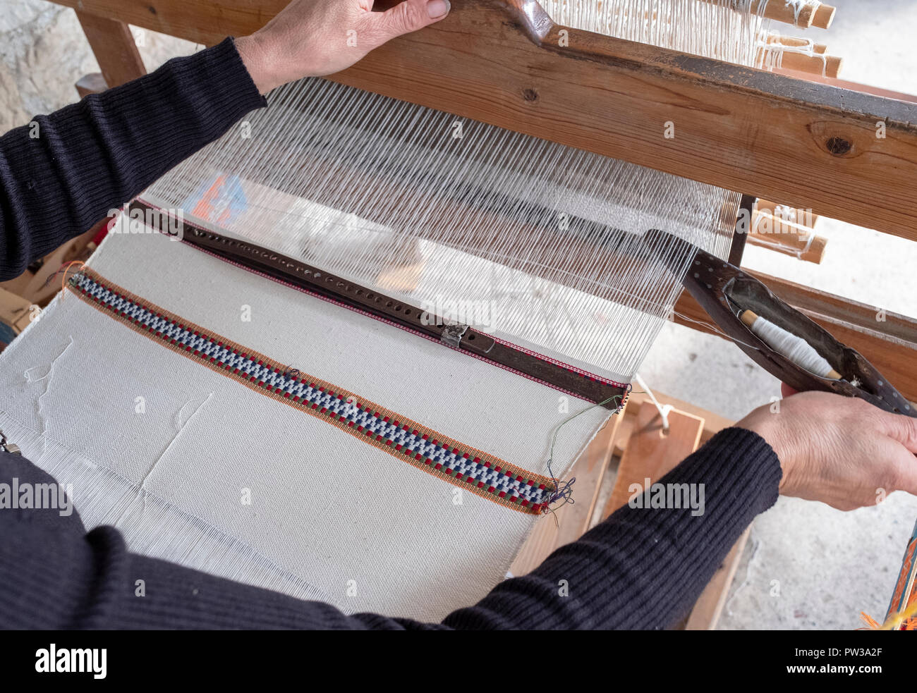 A woman using traditional weaving methods at a Museum in Fyti village, Cyprus. Stock Photo