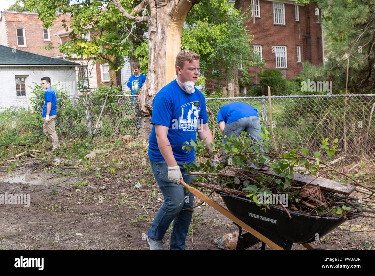 Detroit, Michigan - A Morman missionary joins volunteers cleaning up a distressed neighborhood during a week-long community improvement initiative cal Stock Photo