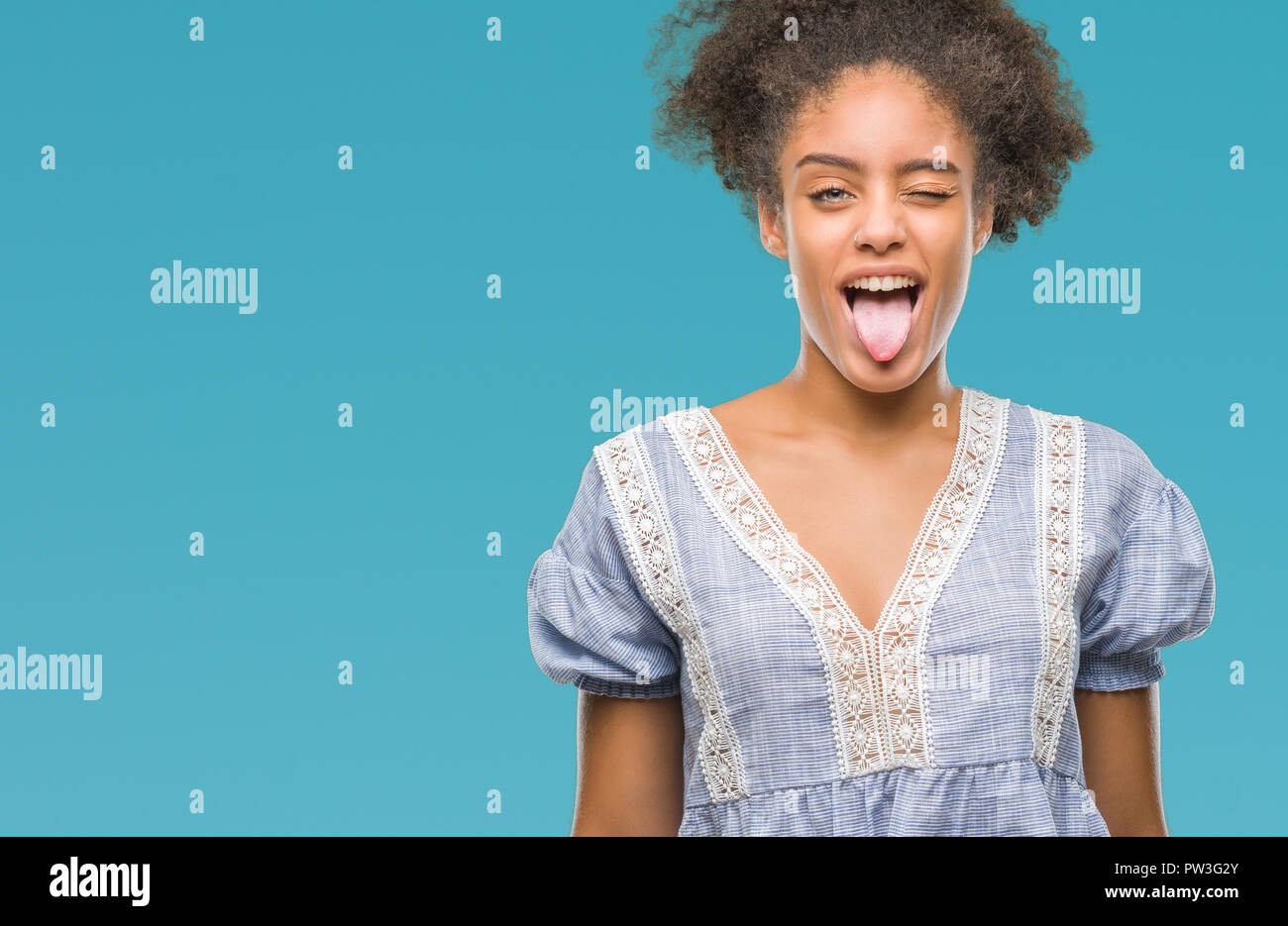 Young afro american woman over isolated background sticking tongue out ...