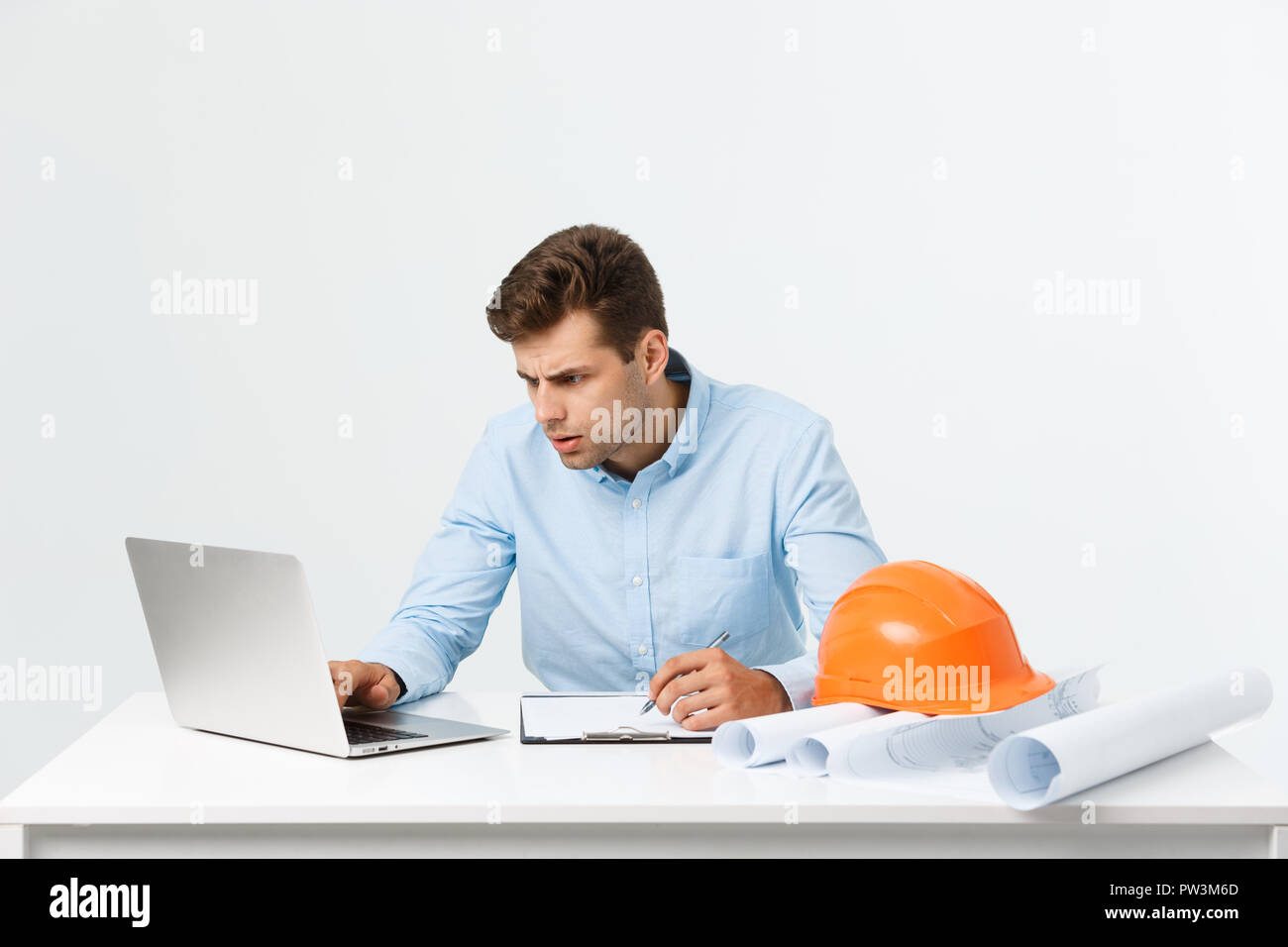 Handsome young man serious working in engineering office. Stock Photo