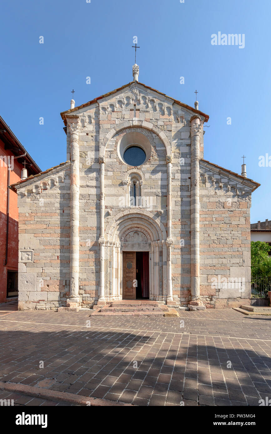 polychrome marble facade of Romanesque church in village on shore of Garda lake, shot in bright fall light at Toscolano-Maderno, Brescia, Italy Stock Photo