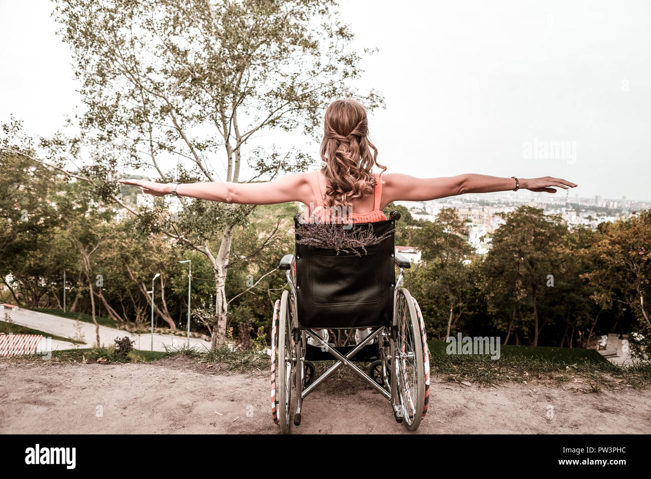 Disabled girl sitting in the wheelchair and doing exercises Stock Photo