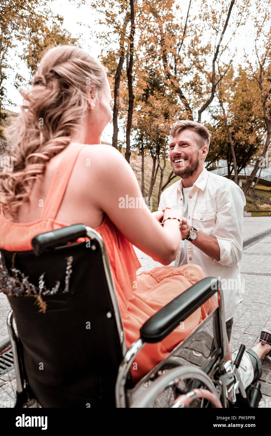 Happy man standing on one knee and asking his girlfriend to marry him Stock Photo