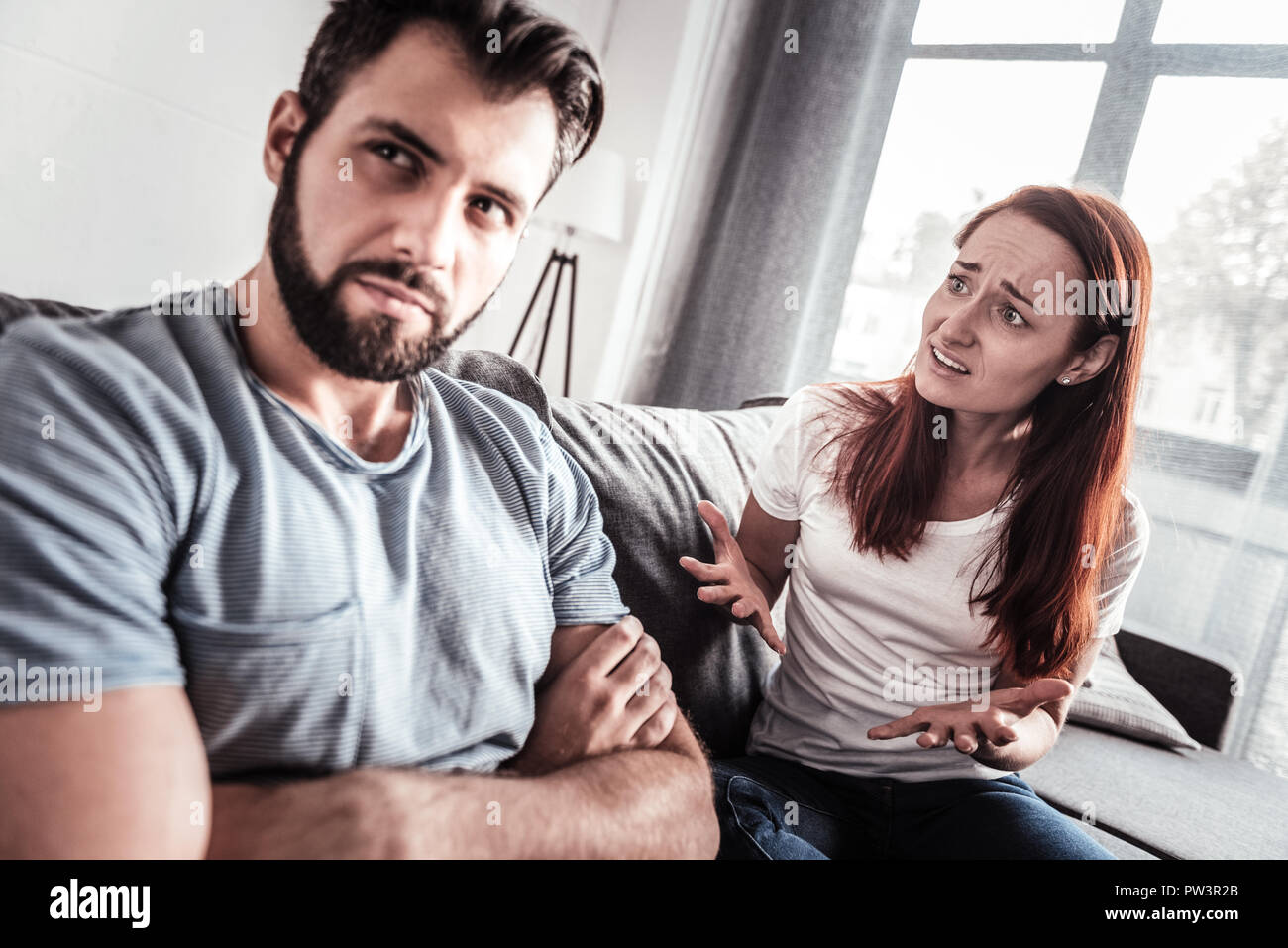 Cheerless unhappy woman talking to her husband Stock Photo - Alamy