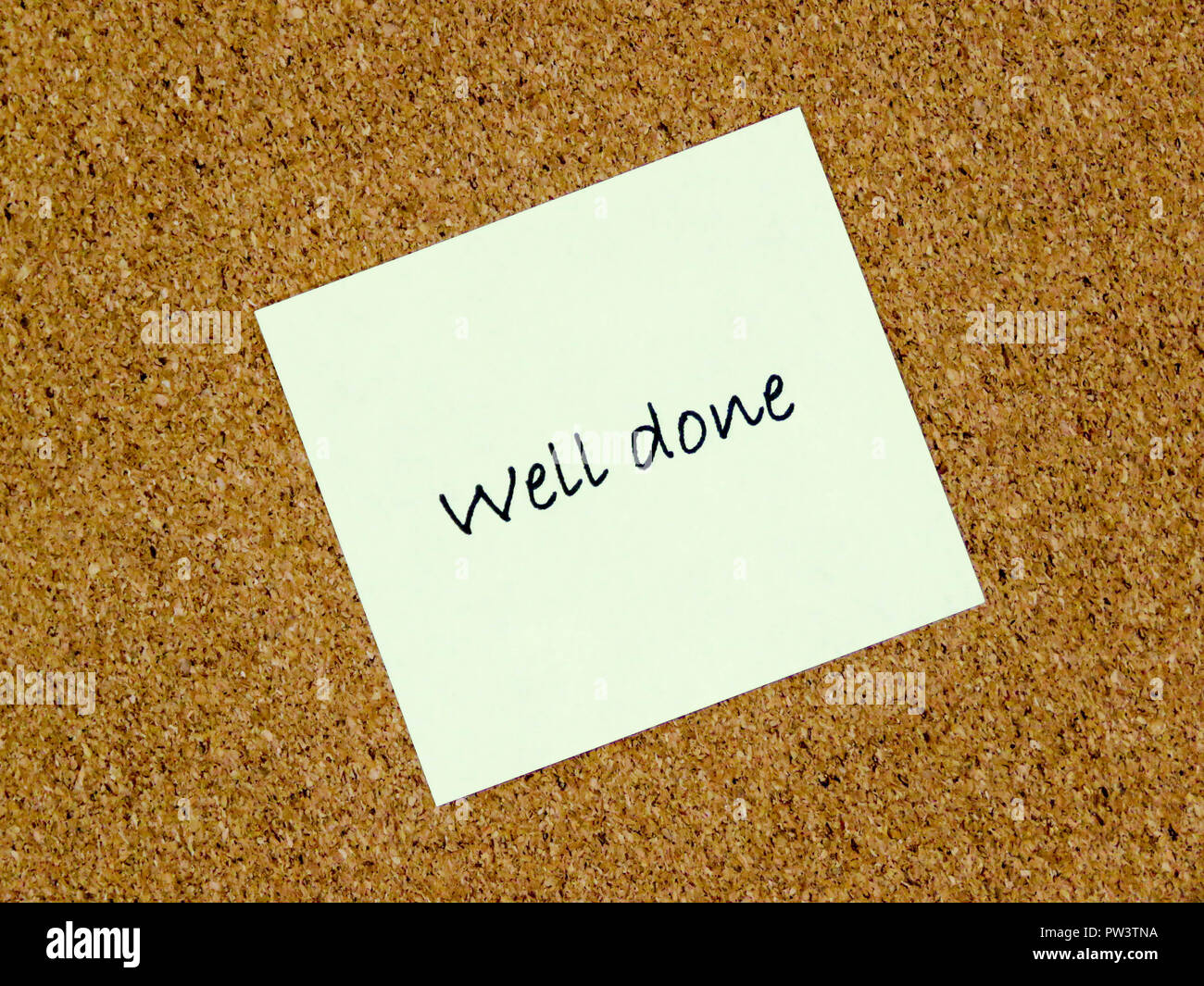 A yellow sticky note with well done written on it on a cork board background Stock Photo