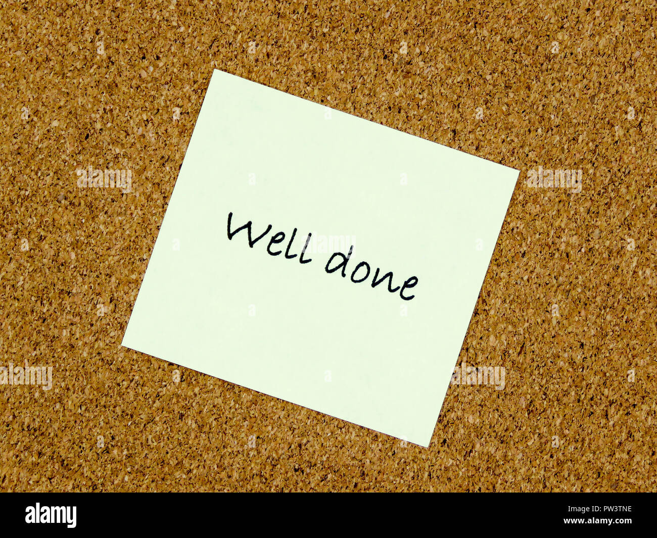 A yellow sticky note with well done written on it on a cork board background Stock Photo