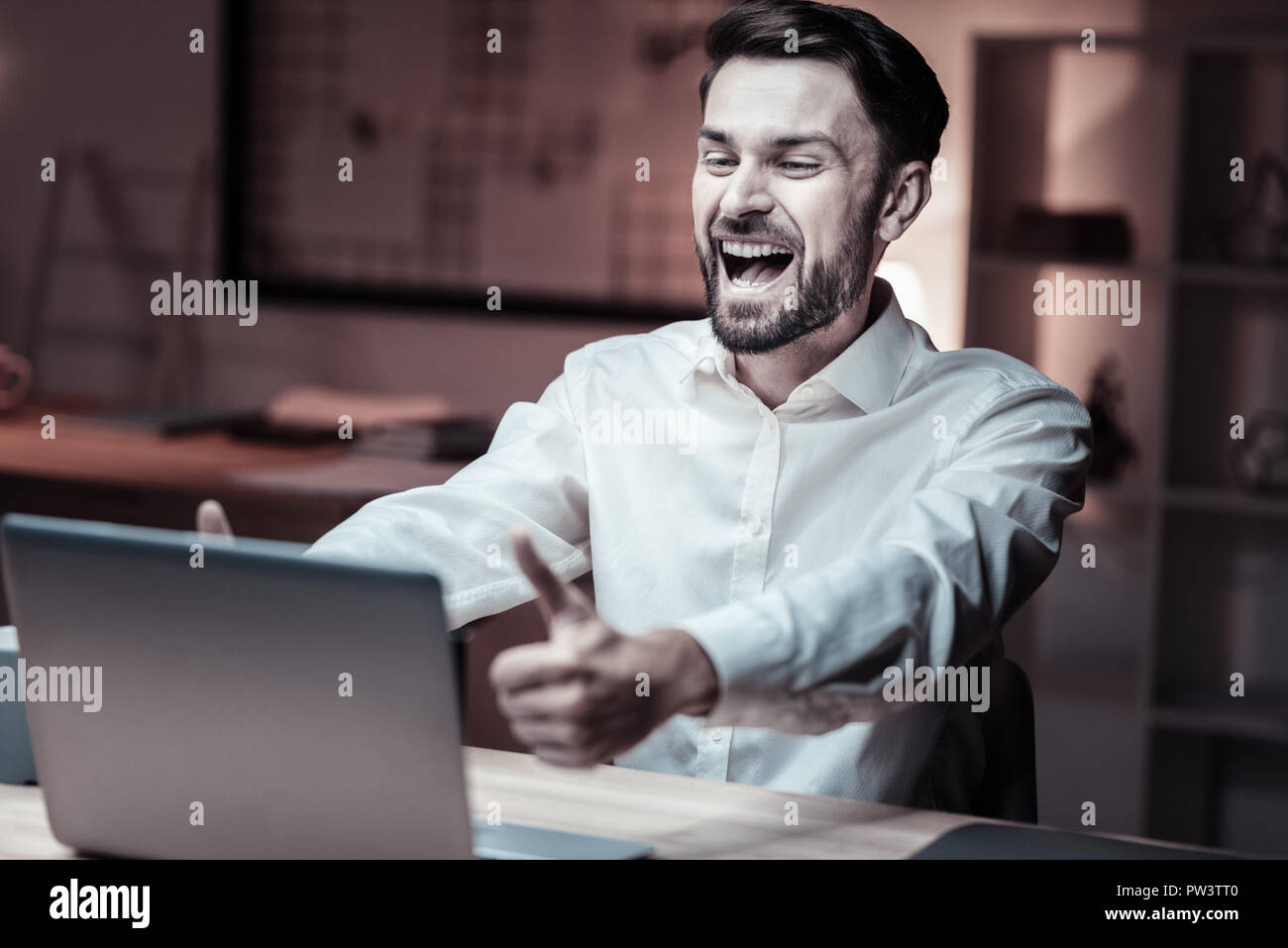 Cheerful bearded man looking at laptop Stock Photo