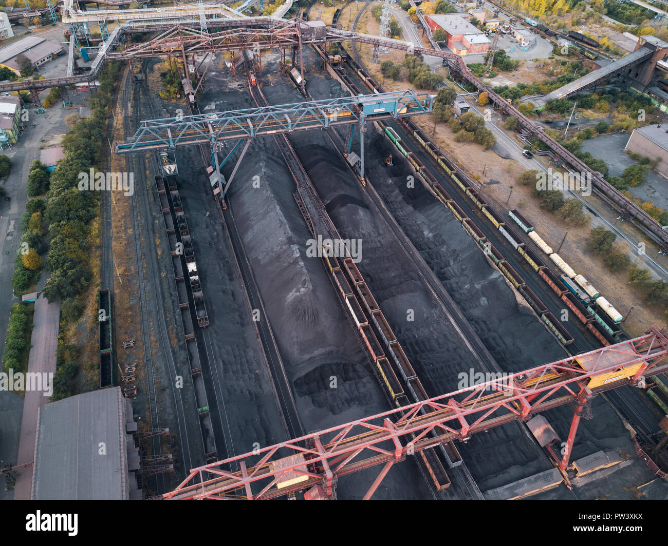 Drone faerial view of moving train with production for export on the huge manufacturing site of one of the world largest steel plant with infrastructu Stock Photo