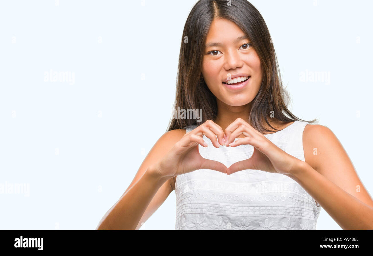 Young asian woman over isolated background smiling in love showing ...