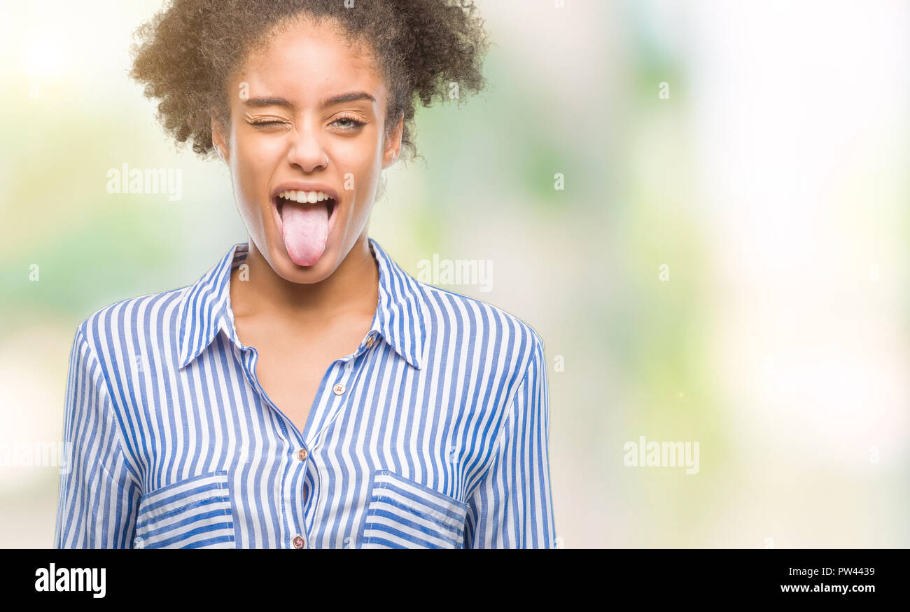 Young afro american woman over isolated background sticking tongue out ...