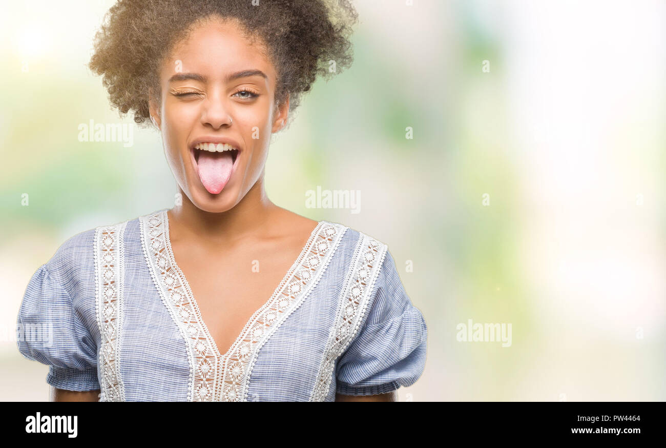 Young afro american woman over isolated background sticking tongue out ...