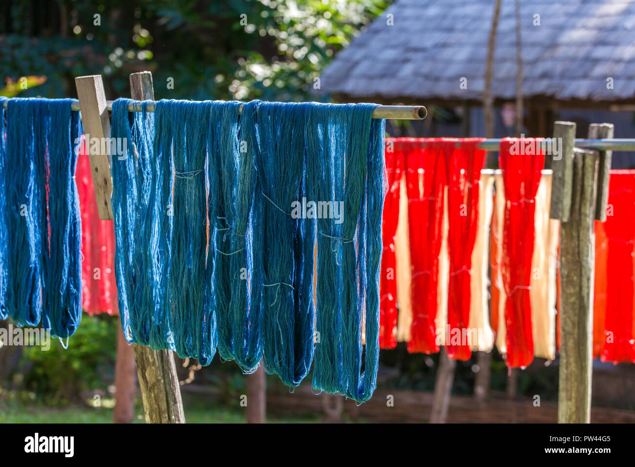 Colorful fabric hanging to dry after traditional dye processs in Luang Prabang, Laos. Silk production factory. Traditional manufacturing in Asia. Stock Photo
