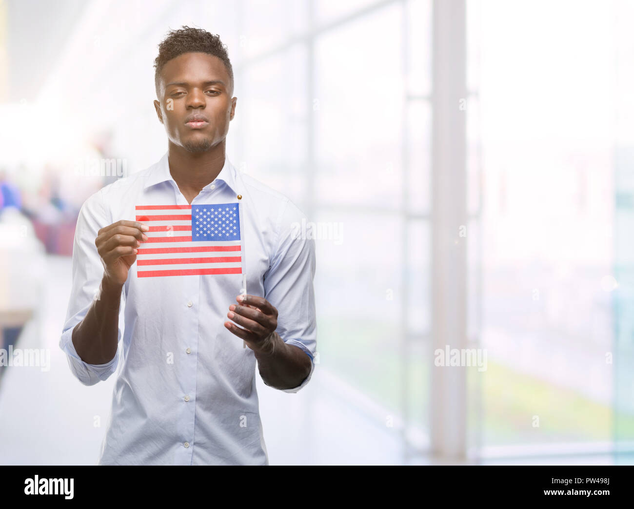 Young african american man holding USA flag with a confident expression ...