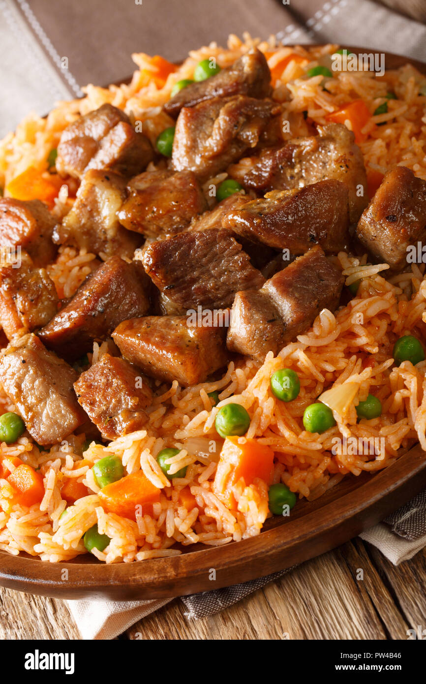 Mexican spicy rice with fried pork close-up on the table. vertical Stock Photo