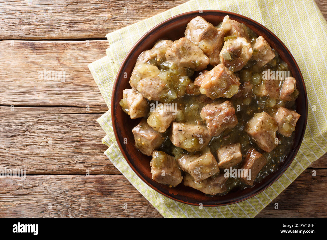 This authentic pork chile verde recipe. Tender pieces of pork slow cooked with a green chile sauce (salsa verde) closeup on the plate. horizontal top  Stock Photo