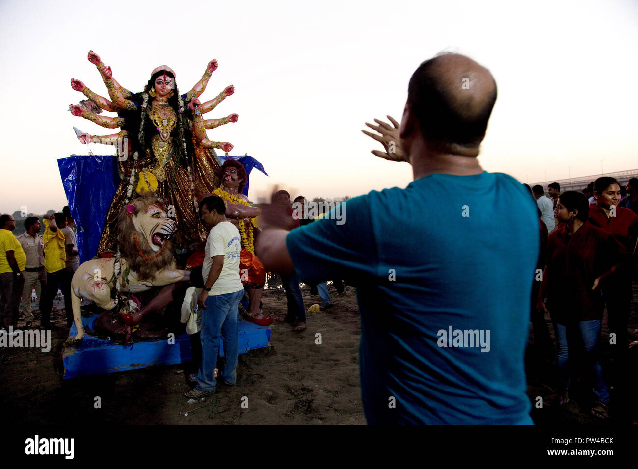 An unidentified man is giving directions to a group of people around an idol of Hindu goddess Durga on the occasion of Durga Visarjan in New Delhi. Stock Photo