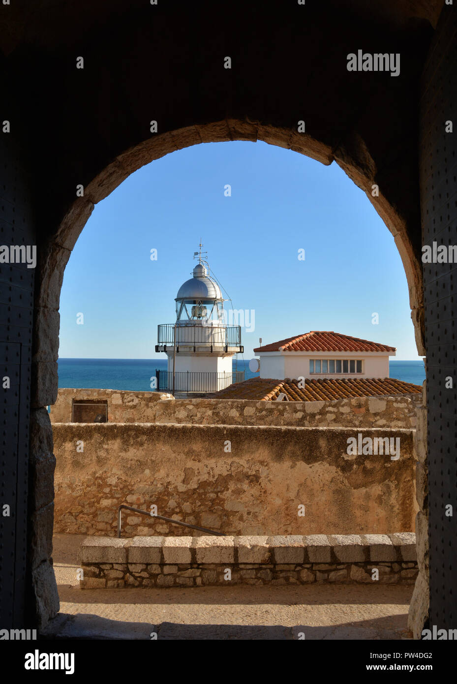 Lighthouse of Peniscola seen from Papa Luna Castle with Mediterranean Sea as Background. Peniscola is a popular tourist destination in Spain. Stock Photo