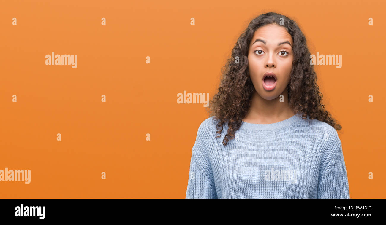 Beautiful young hispanic woman scared in shock with a surprise face ...