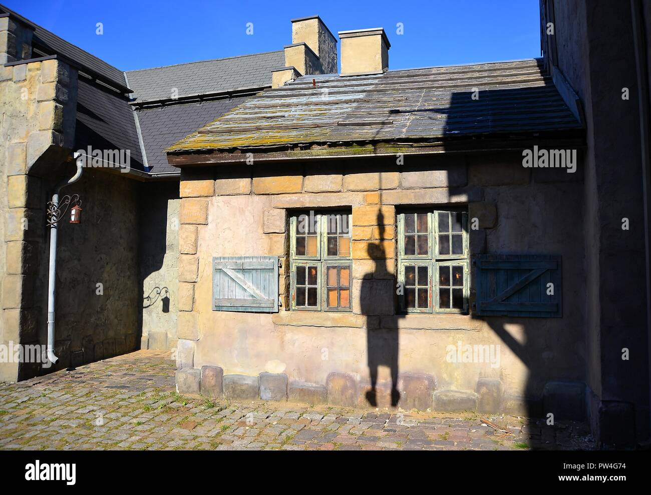 Shadow of a hanged man on the facade of a medieval house Stock Photo