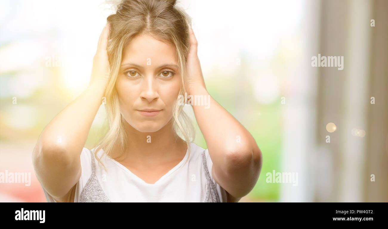 Young beautiful woman covering ears ignoring annoying loud noise, plugs