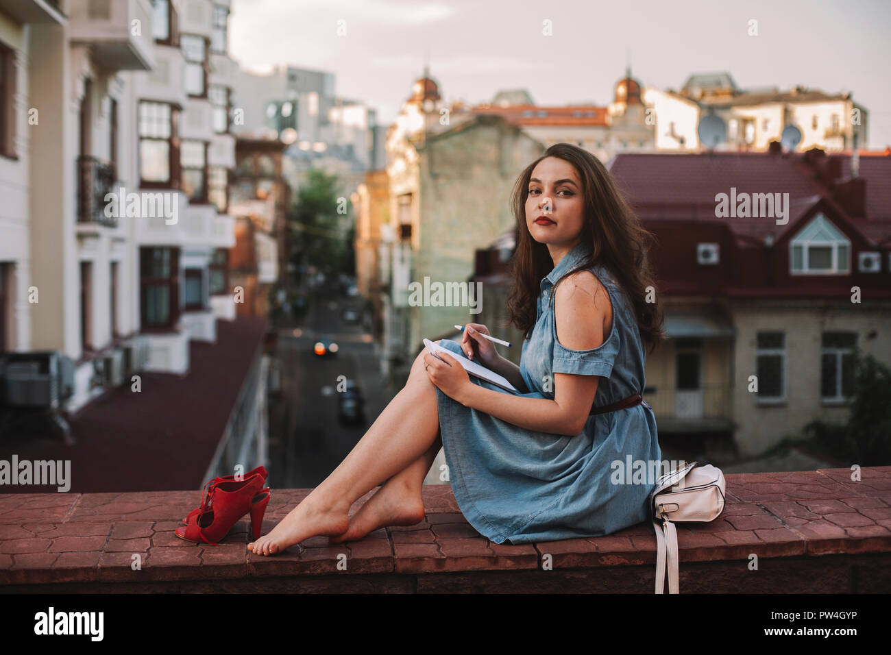 Young woman sitting wall city hi-res stock photography and images - Alamy
