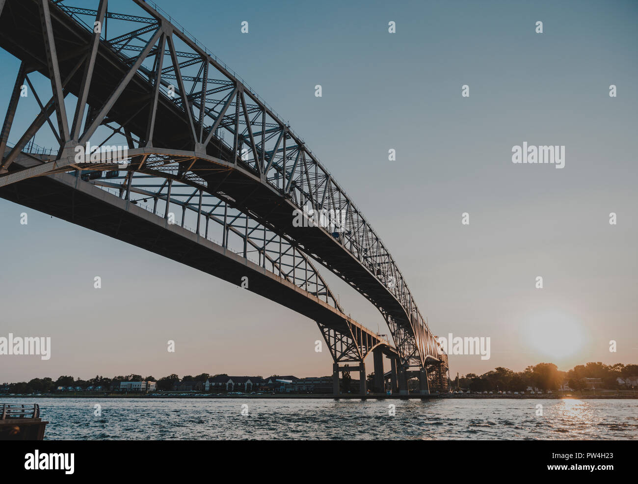 Low angle view of Blue Water Bridge over Saint Clair River against clear sky during sunset Stock Photo
