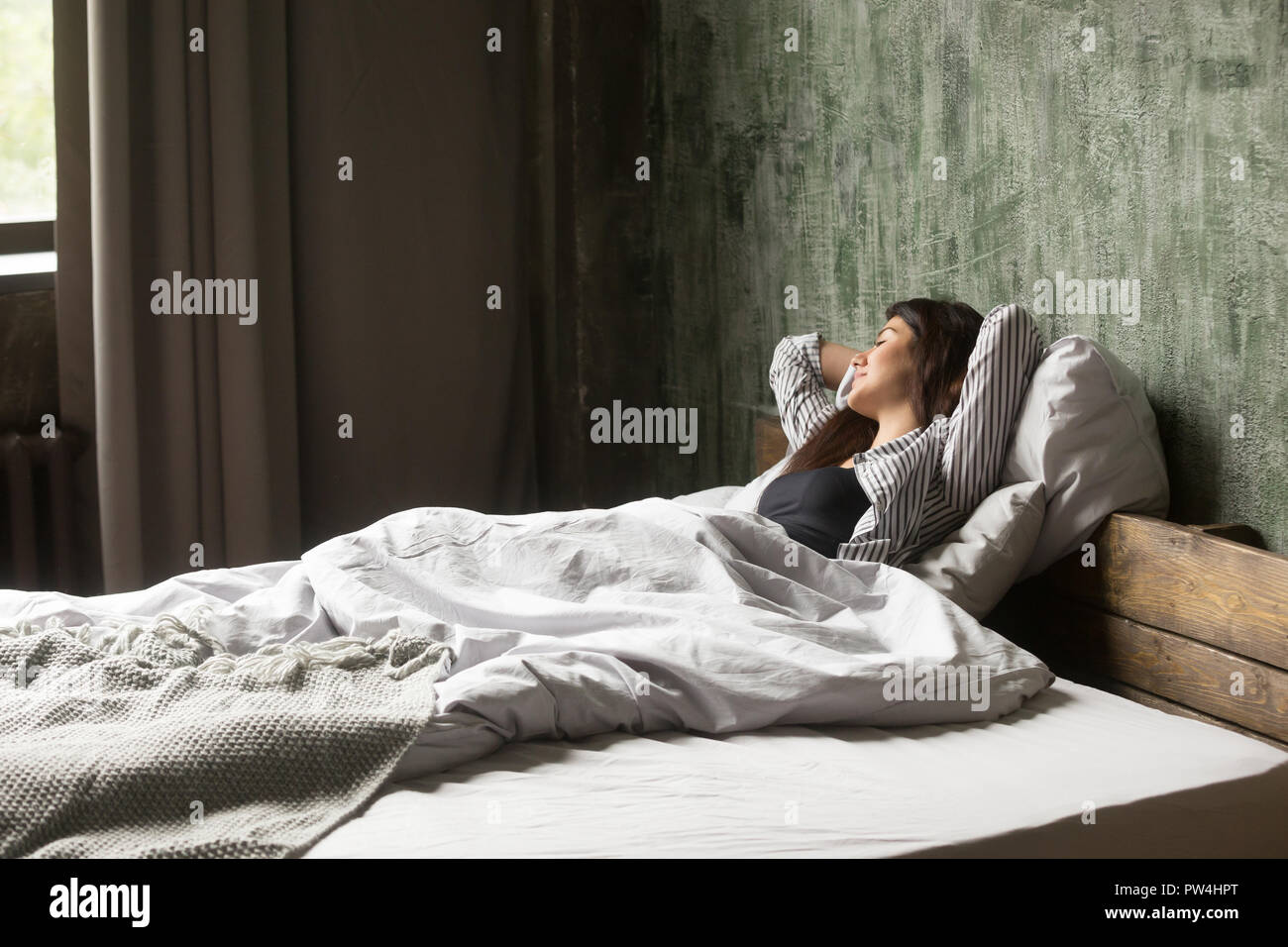 Woman lying and resting in bed on bedroom at home Stock Photo