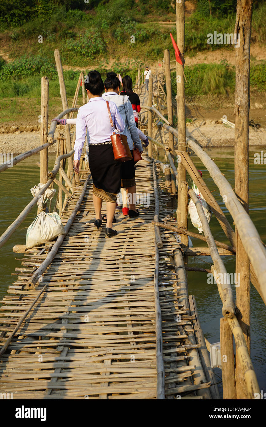Frauen überqueren temporäre Bambusbrücke über den Nam Khan Fluß, Luang Prabang, Laos Stock Photo