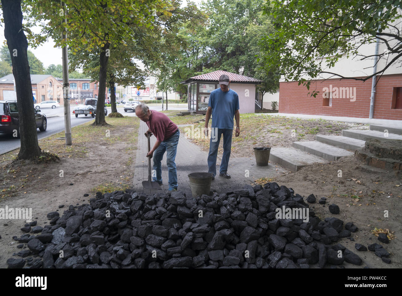 Men move a coal delivery into an apartment building in Zielona Gora, Poland. Some old buildings still use coal for heating. Stock Photo
