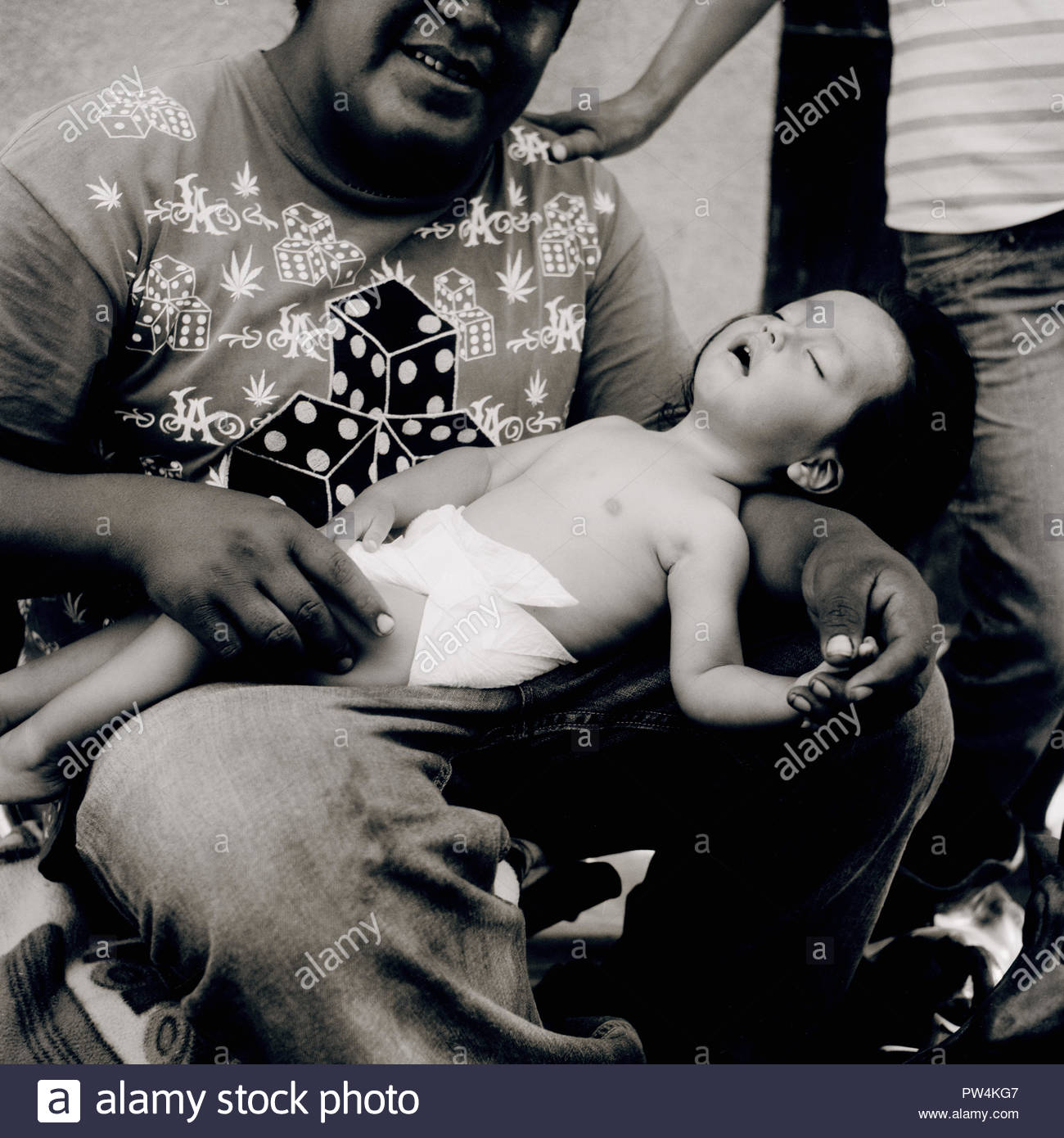 A Baby Being Cradled In His Fathers Arms Stock Photo Alamy