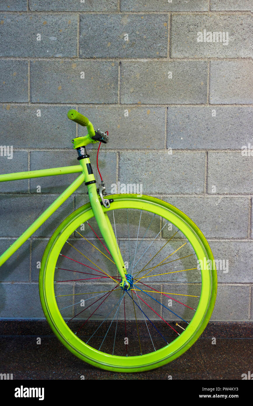 Green bicycle parked by wall in creative office Stock Photo