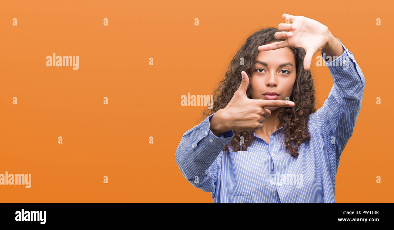 Young hispanic business woman smiling making frame with hands and ...
