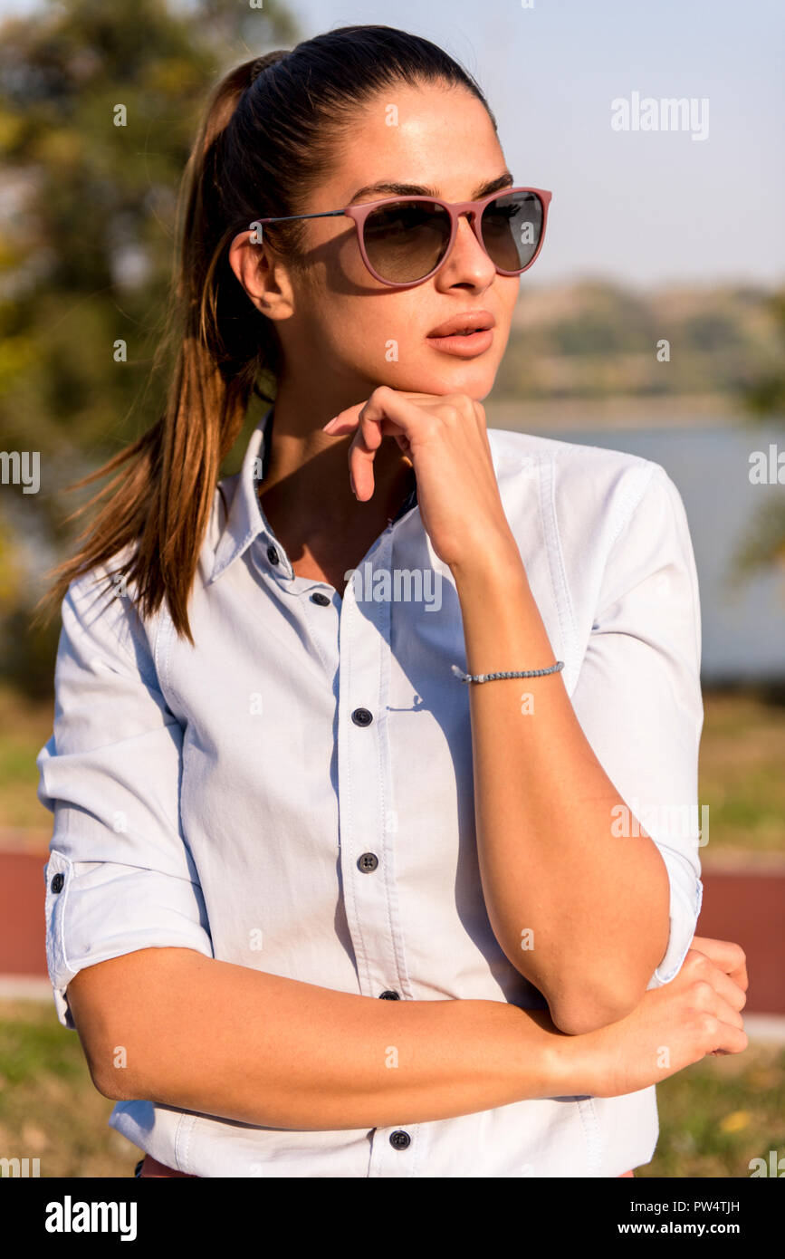 Portrait of beautiful woman wearing sunglasses posing at outdoor on sunny  day Stock Photo - Alamy