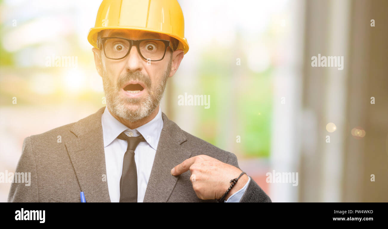 Senior architect or engineer happy and surprised cheering expressing wow gesture, pointing with finger Stock Photo