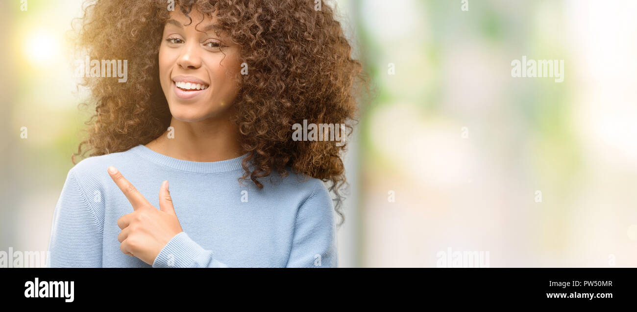 African american woman wearing a sweater cheerful with a smile of face ...