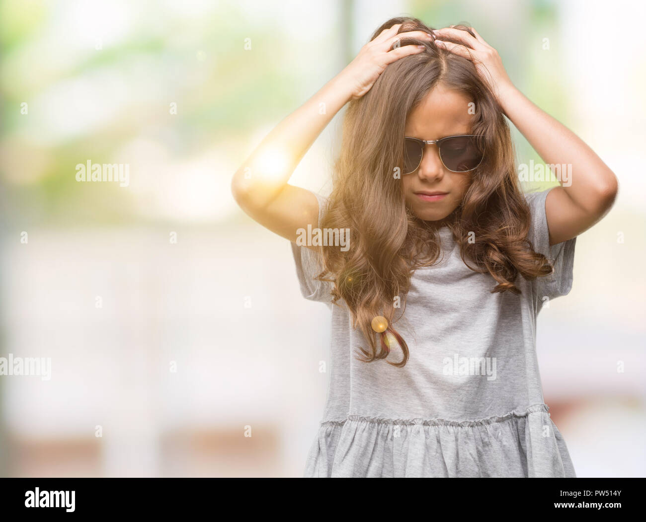hispanic girl wearing sunglasses suffering from headache