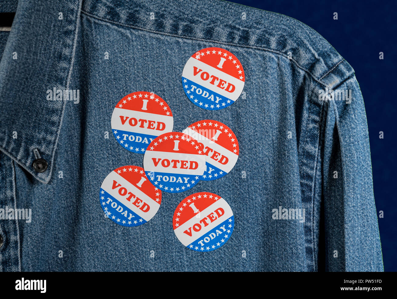 Blue denim working clothing with many Voted stickers on dark background Stock Photo