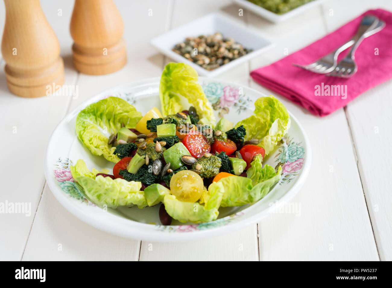 Tri-colour salad with beans, tomatoes, kale and avocado on a bed of little gem lettuce. Stock Photo